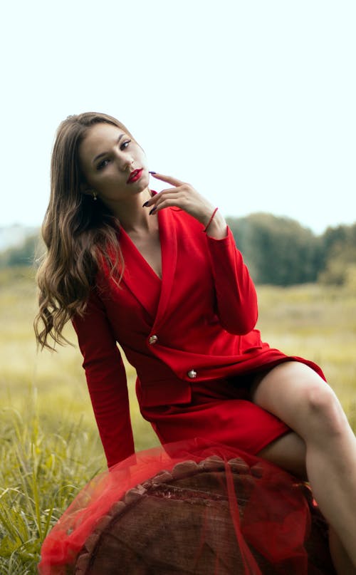 Woman in a Red Coat Sitting while Looking at the Camera