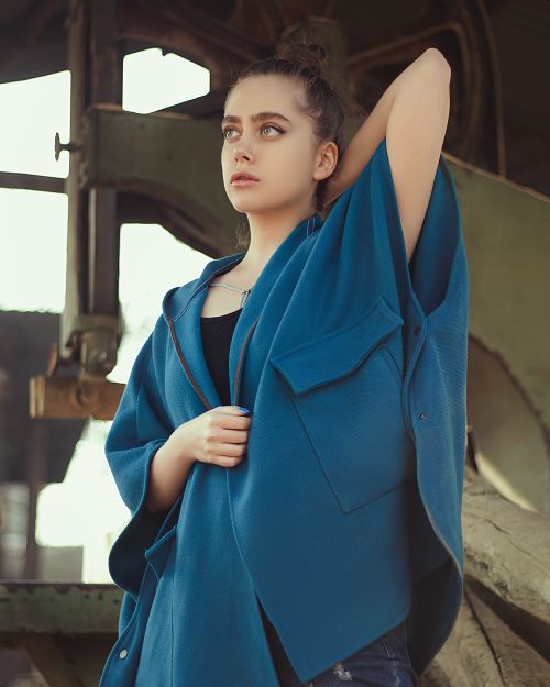 Free Elegant portrait of a young woman posing in a blue coat outdoors in Moscow. Stock Photo