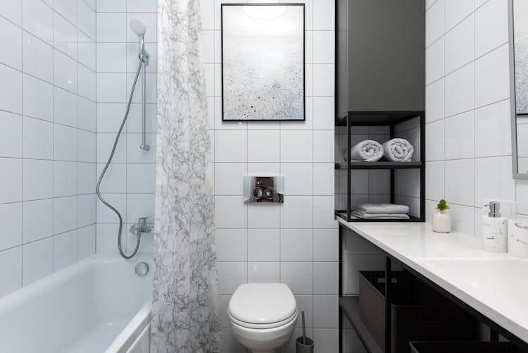 Bathroom Interior With Toilet Near Bathtub With Shower Near Cupboard