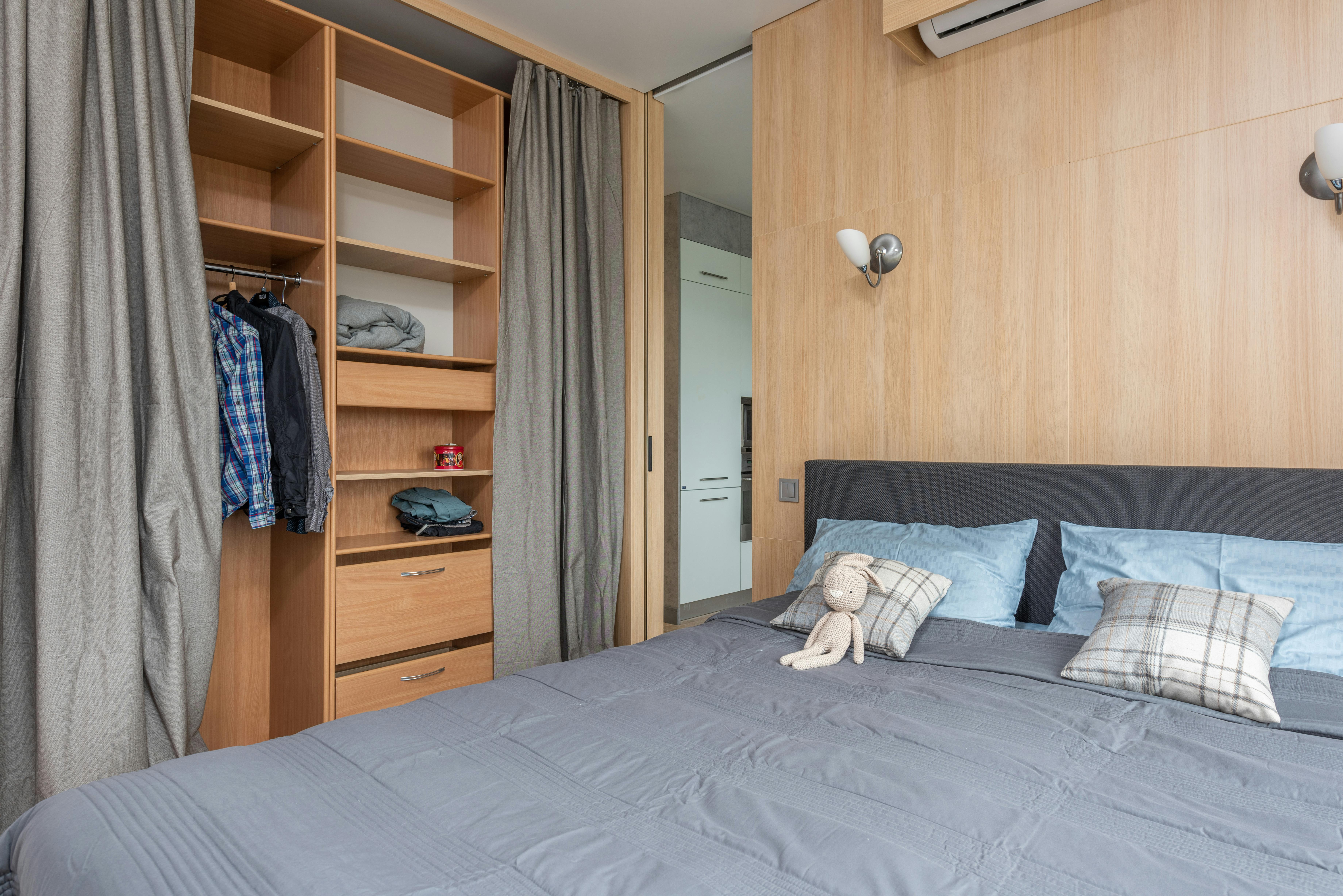 interior of studio with bed near cupboard with shelves