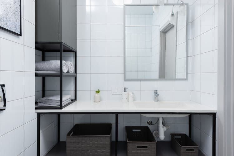 Modern Bathroom Interior With Counter Near Mirror And Shelves