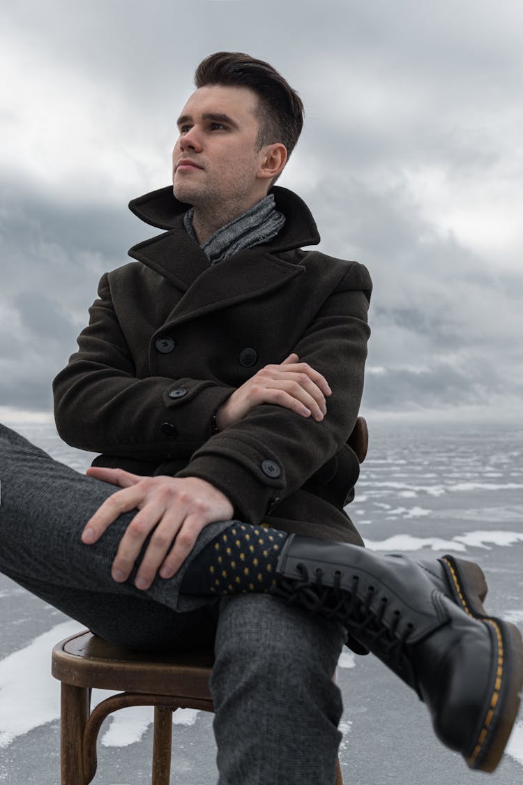 A Man Sitting In A Chair Outdoor 