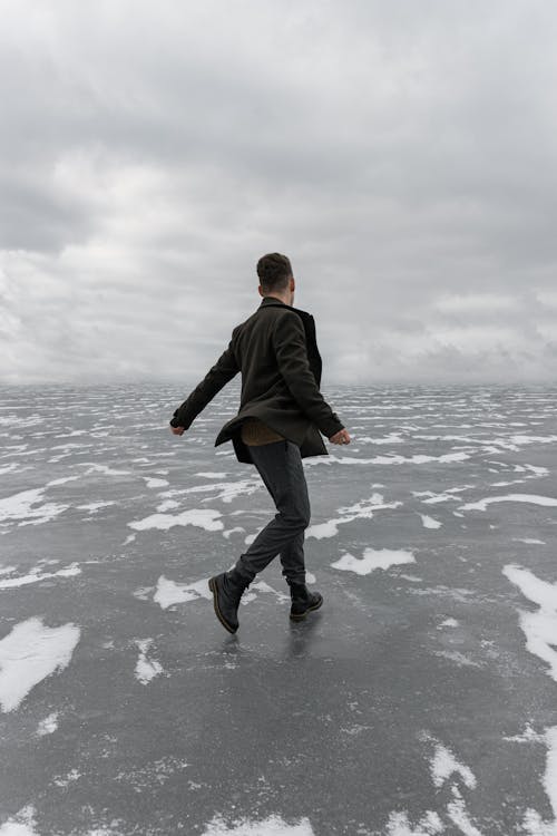 A Person in Jacket Walking on Frozen Lake