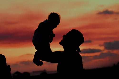 A Silhouette of a Father Carrying His Child