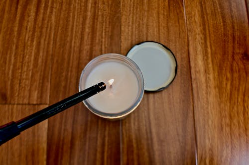 A Close-Up Shot of a Person Lighting a Candle Jar