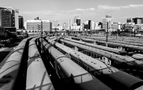 Free Grayscale Photo of City Buildings Near Train Station Stock Photo