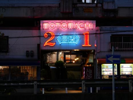 Neon-lit entrance in Kobe, Japan, showcasing vibrant street ambiance at night.