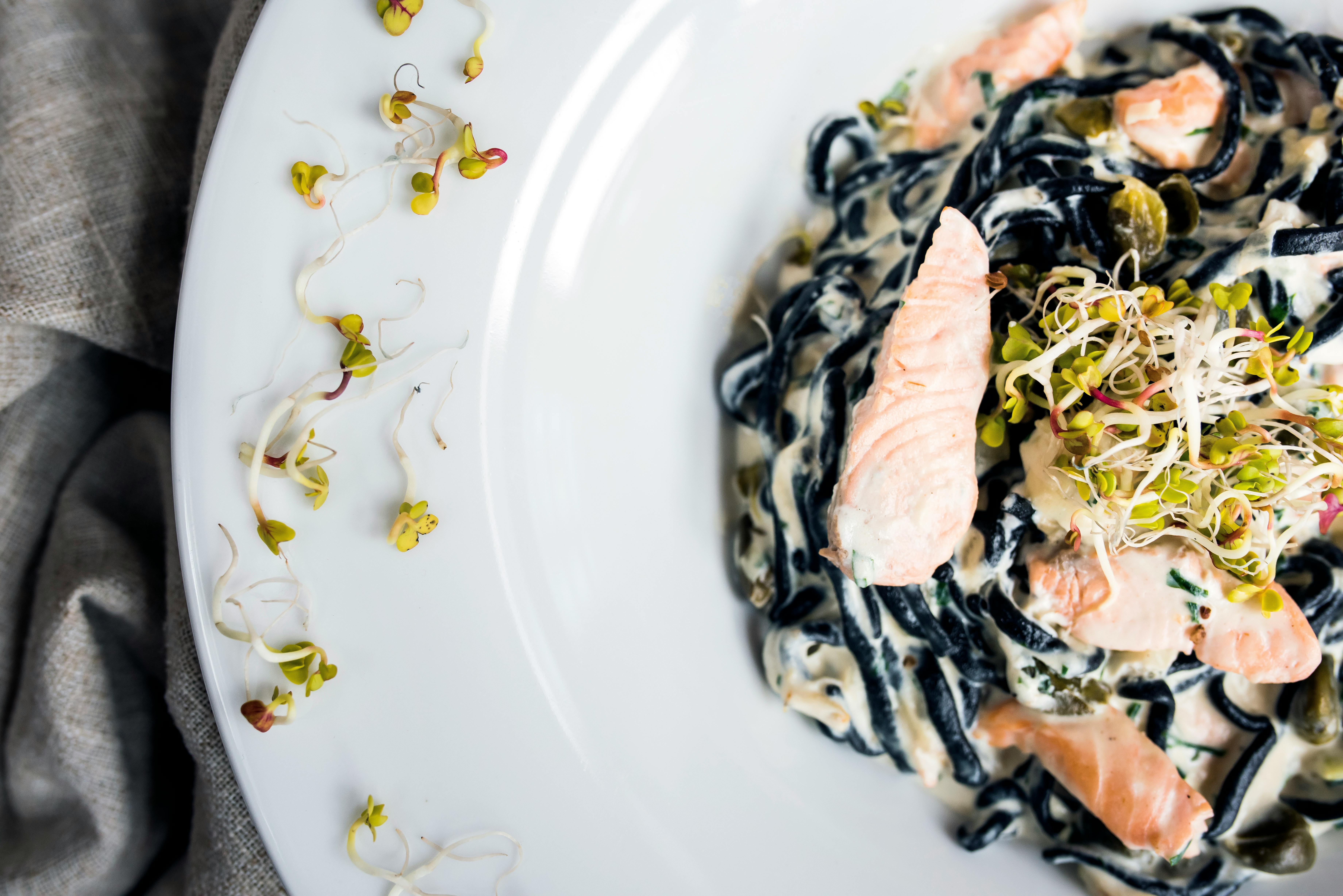 tasty pasta with fish slices and seed sprouts