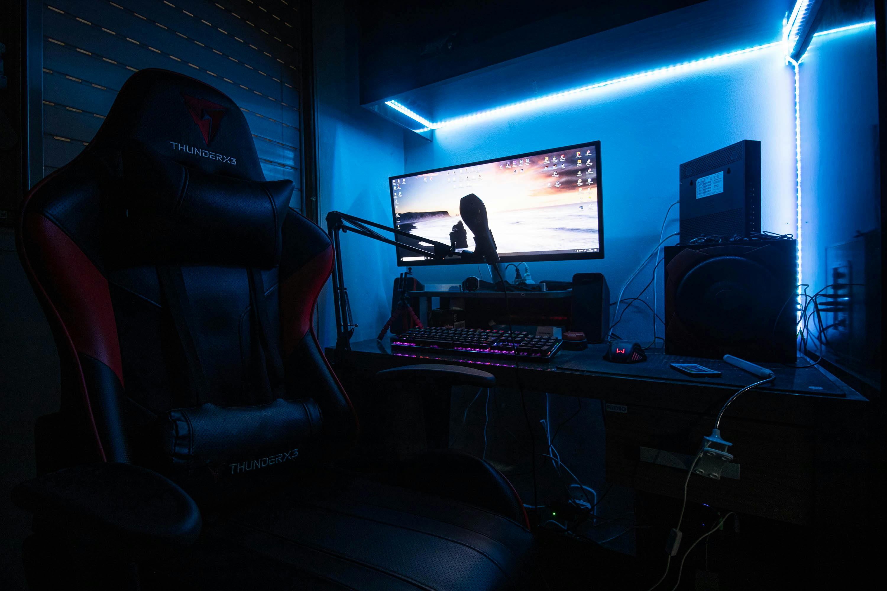 Desktop Computer with Speakers and Gaming Chair in a Room with Blue Light ·  Free Stock Photo