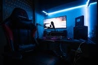 Desktop Computer with Speakers and Gaming Chair in a Room with Blue Light