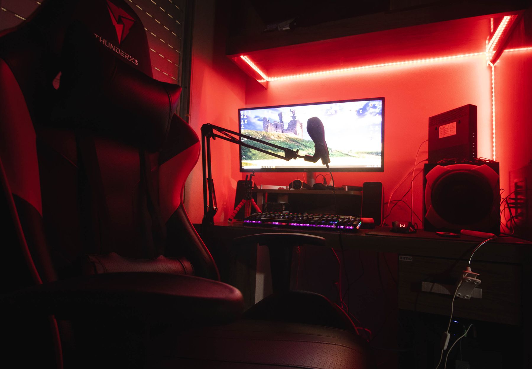 Premium gaming station with gaming chair, monitor, keyboard, mouse and organized illuminated desktop
