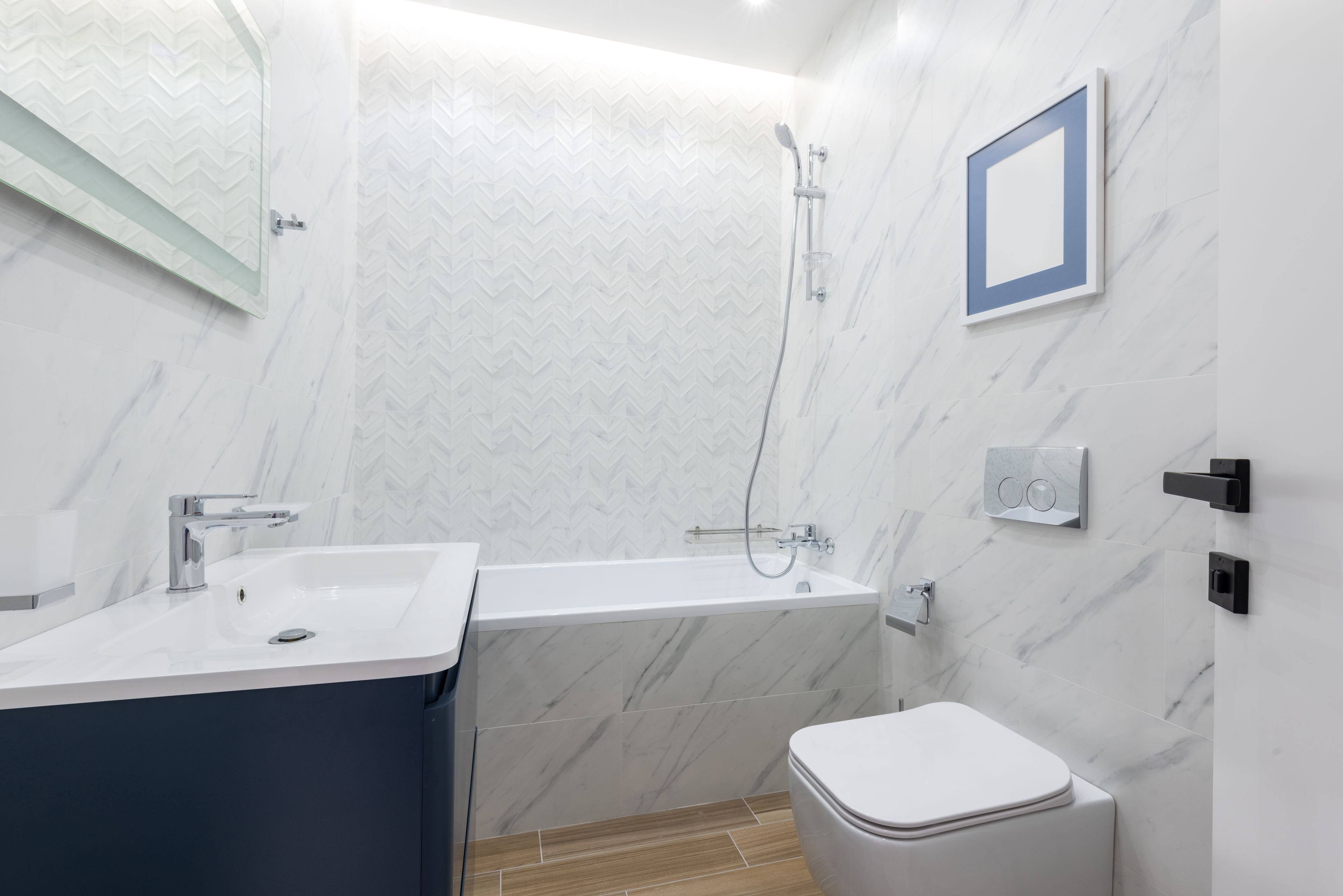 A marble bathroom with a deep blue tub