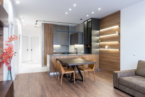 Free Contemporary kitchen with modern appliances placed near table with chairs in spacious apartment with couch and white doors in corridor Stock Photo