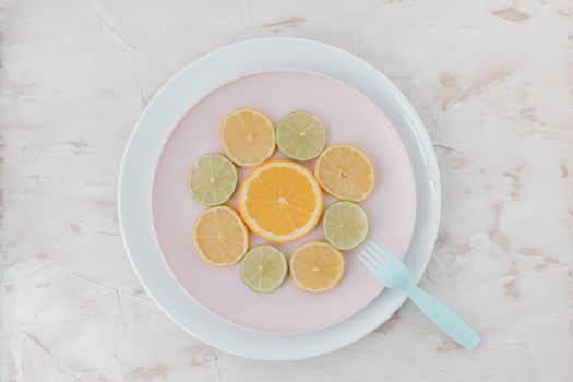 Top view of citrus slices on ceramic plates, showcasing lime and orange artistry.