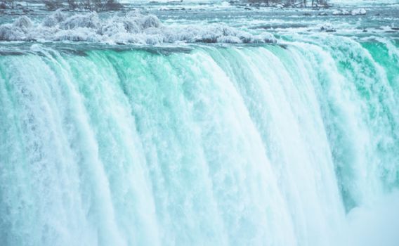 Close-up of a majestic waterfall cascading into rapids, showcasing nature's force.