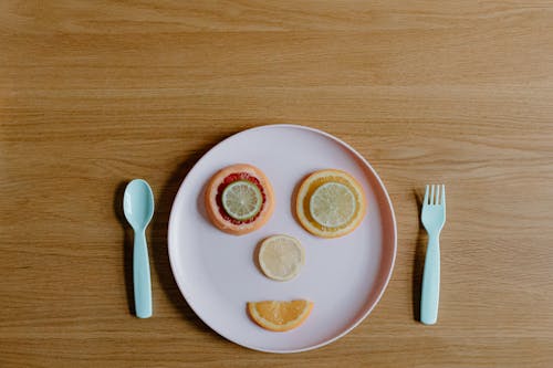 Slices of fresh ripe citruses forming funny face on plate