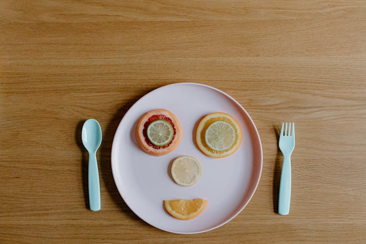 Slices Of Fresh Ripe Citruses Forming Funny Face On Plate