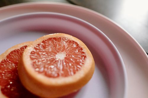 Free From above closeup of cut fresh juicy grapefruit placed in ceramic plate in daylight Stock Photo