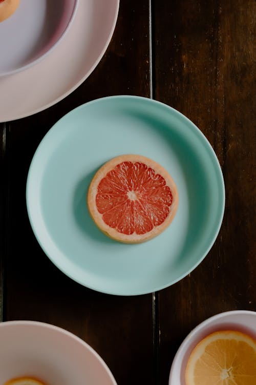 Plates with citrus fruits on table