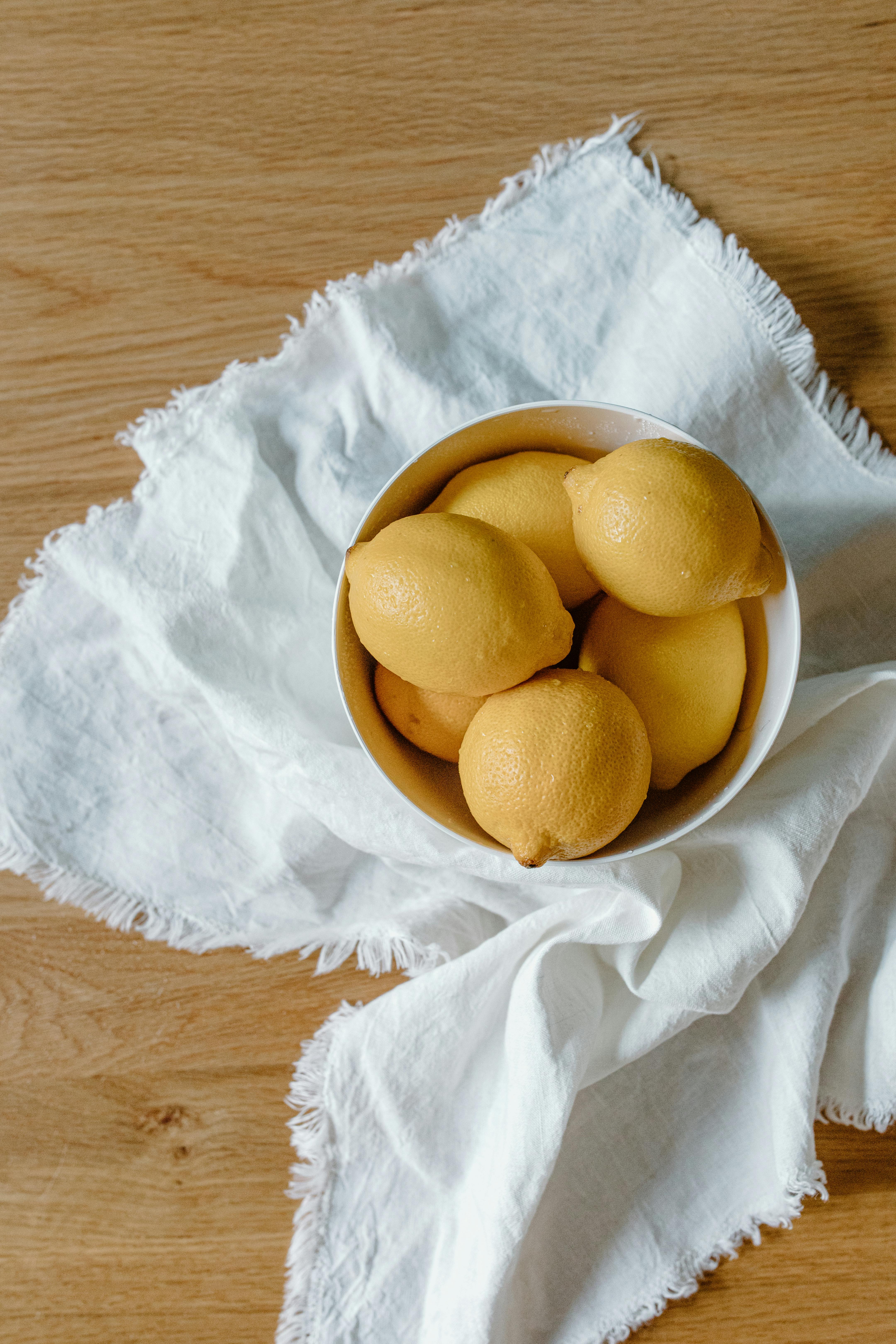 fresh lemons on bowl on cloth