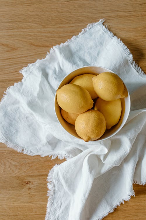 Fresh lemons on bowl on cloth