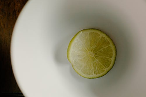 Top view of slice of green lime in plastic bowl for healthy dish