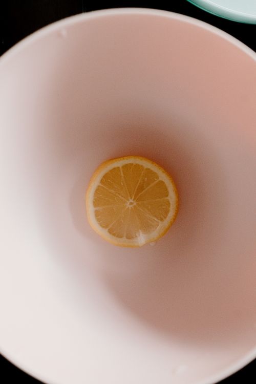 Free Top view of ripe yellow half of lemon placed in white bowl for breakfast Stock Photo