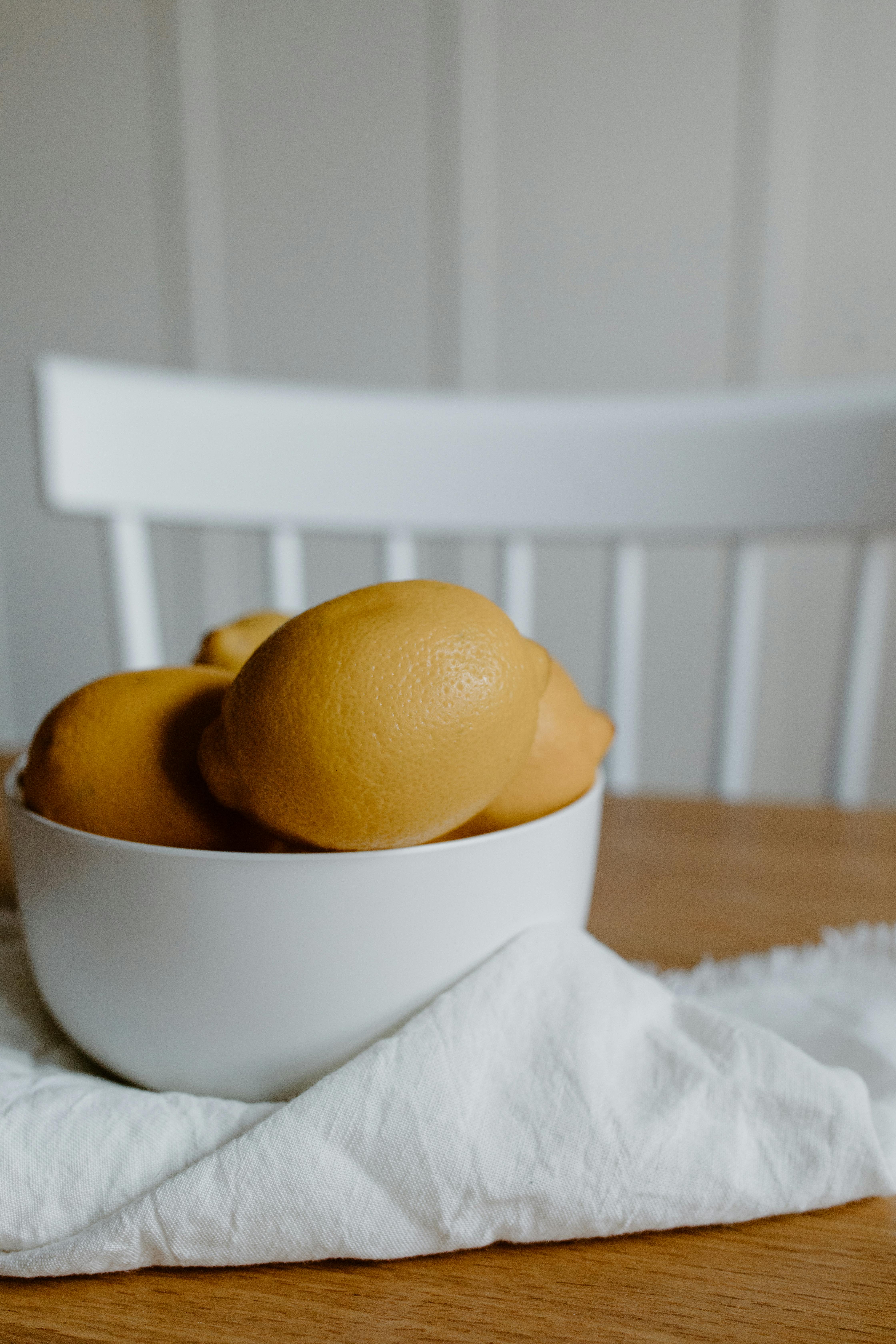 lemons in bowl with napkin on table near chair