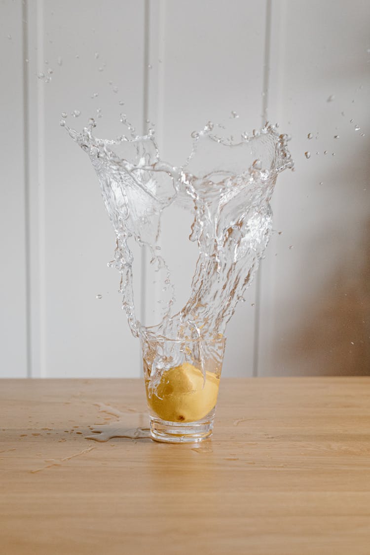 Sliced Lemon Dropped In A Glass