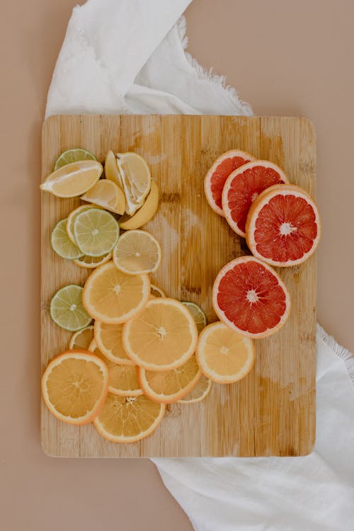 Sliced Citrus Fruits on Brown Wooden Chopping Board