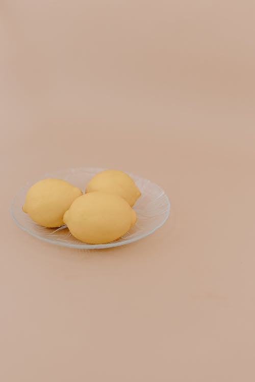 Plate with lemons on beige surface