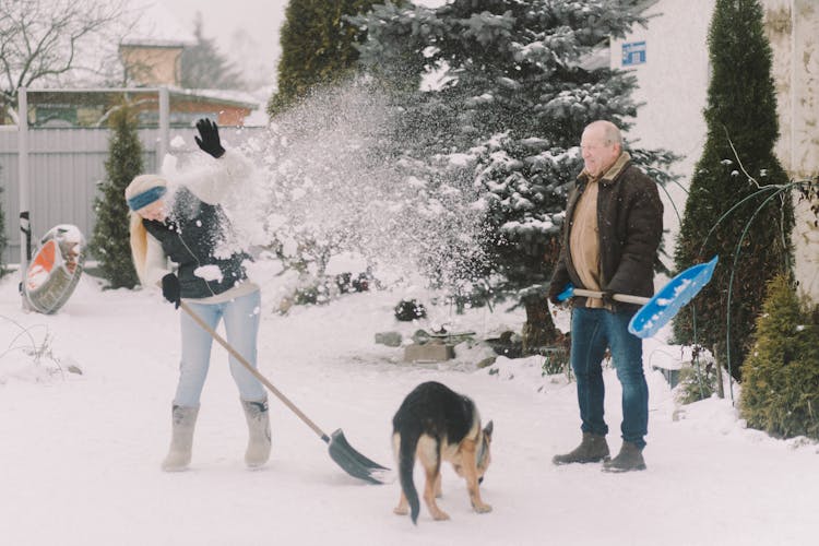 An Elderly Couple Shoveling Snow