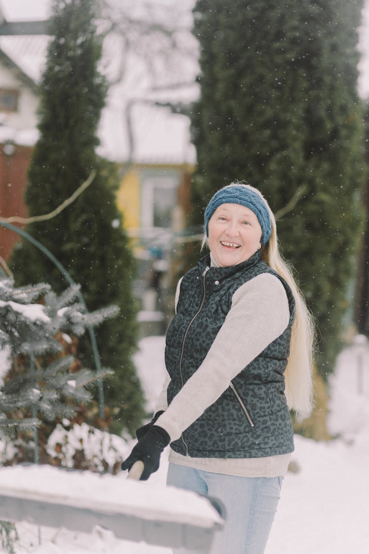 Woman Carrying A Shovel With Snow