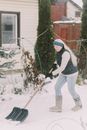 Woman in Long Sleeve Shirt and Denim Pants Plowing Snow with Shovel