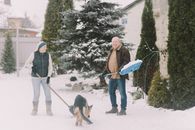 Couple Shoveling Snow with Dog