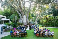 Anonymous newlyweds holding hands near guests during wedding ceremony