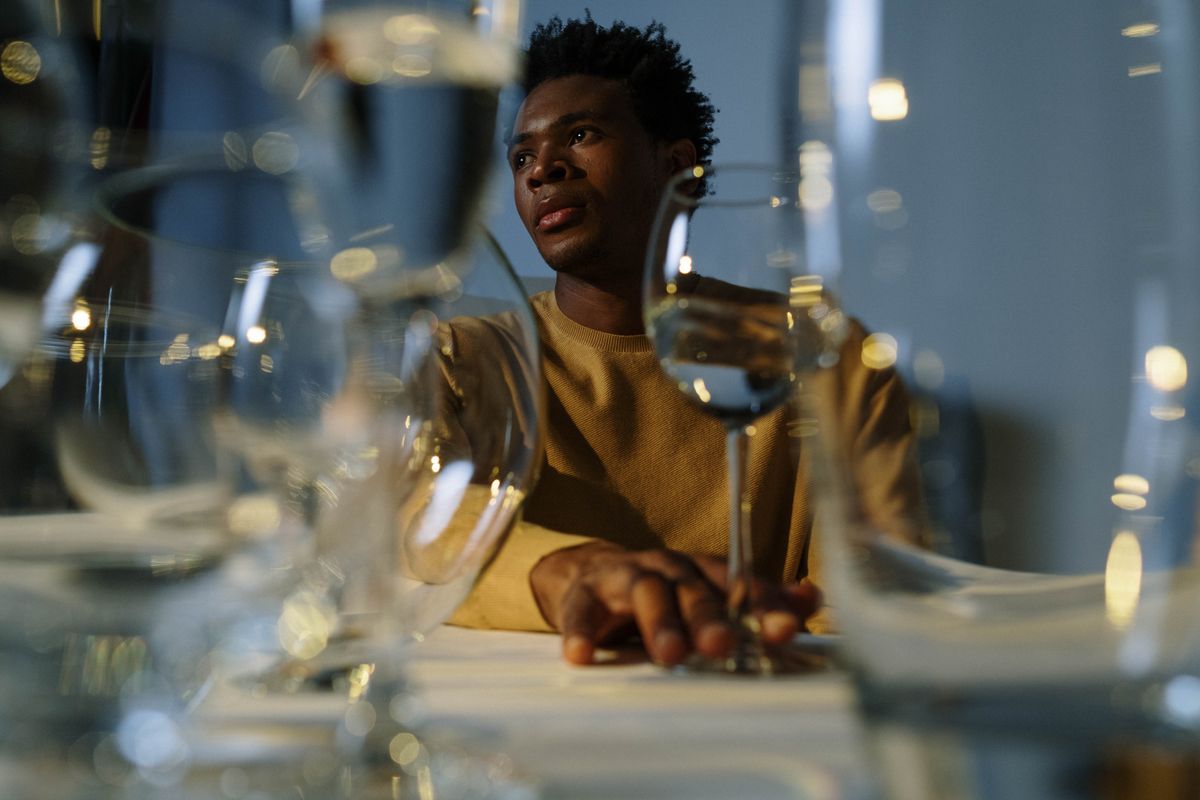 Person thoughtfully considering a glass of wine, representing the changed relationship with alcohol after bariatric surgery