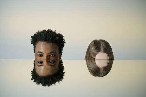 Free Man With Curly Hair and Person's Forehead Reflecting on Mirror Stock Photo