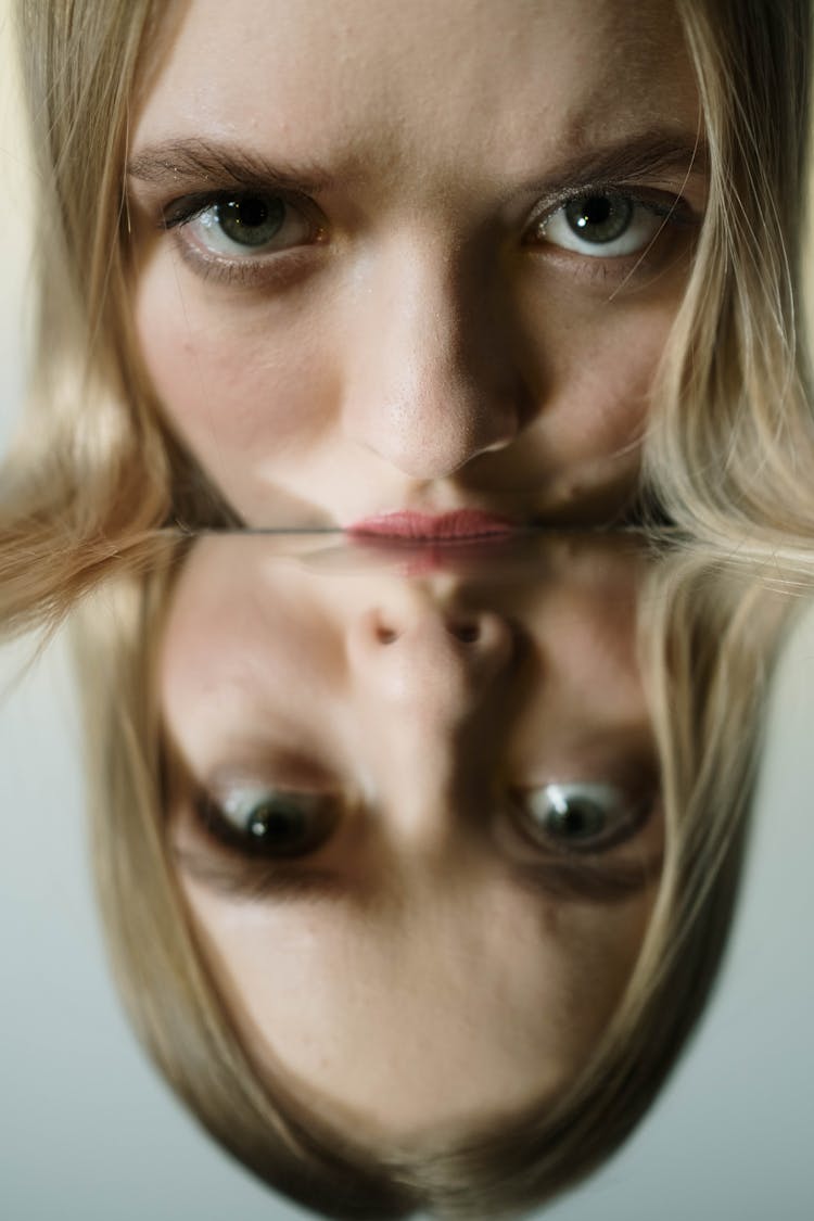 Woman's Face Resting On A Mirrored Surface