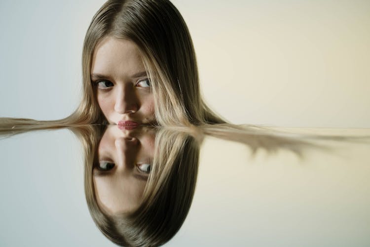 Woman Resting Her Lips On A Mirrored Surface