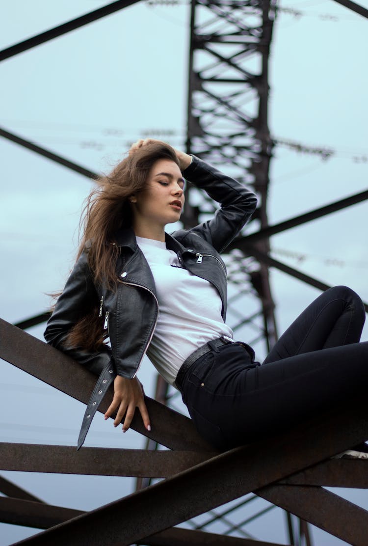 Woman Posing On Lattice Transmission Tower