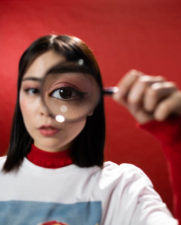 Free Woman Holding a Magnifying Glass Stock Photo