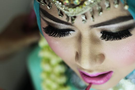 Detailed close-up of a woman applying makeup, focusing on her eye makeup and lips.
