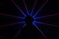 Silhouette of Man Standing in Front of Purple Light