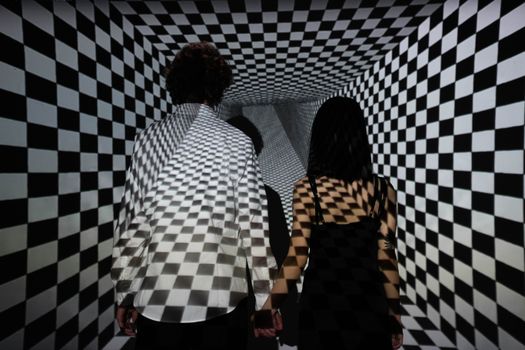 A Couple Standing Together in a Checkerboard Projection