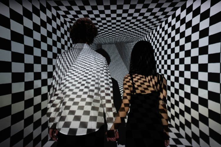 A Couple Standing Together In A Checkerboard Projection