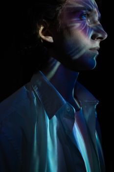 A dramatic profile of a young man with colorful prism lighting, creating a mystical and abstract atmosphere.
