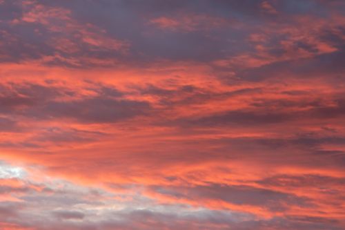 Free A vibrant sunset sky with dramatic clouds in warm hues, creating a serene and atmospheric scene. Stock Photo