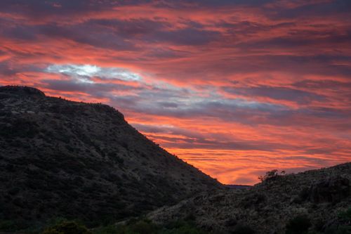 Free Captivating sunset over mountains with vibrant red and orange clouds. Stock Photo