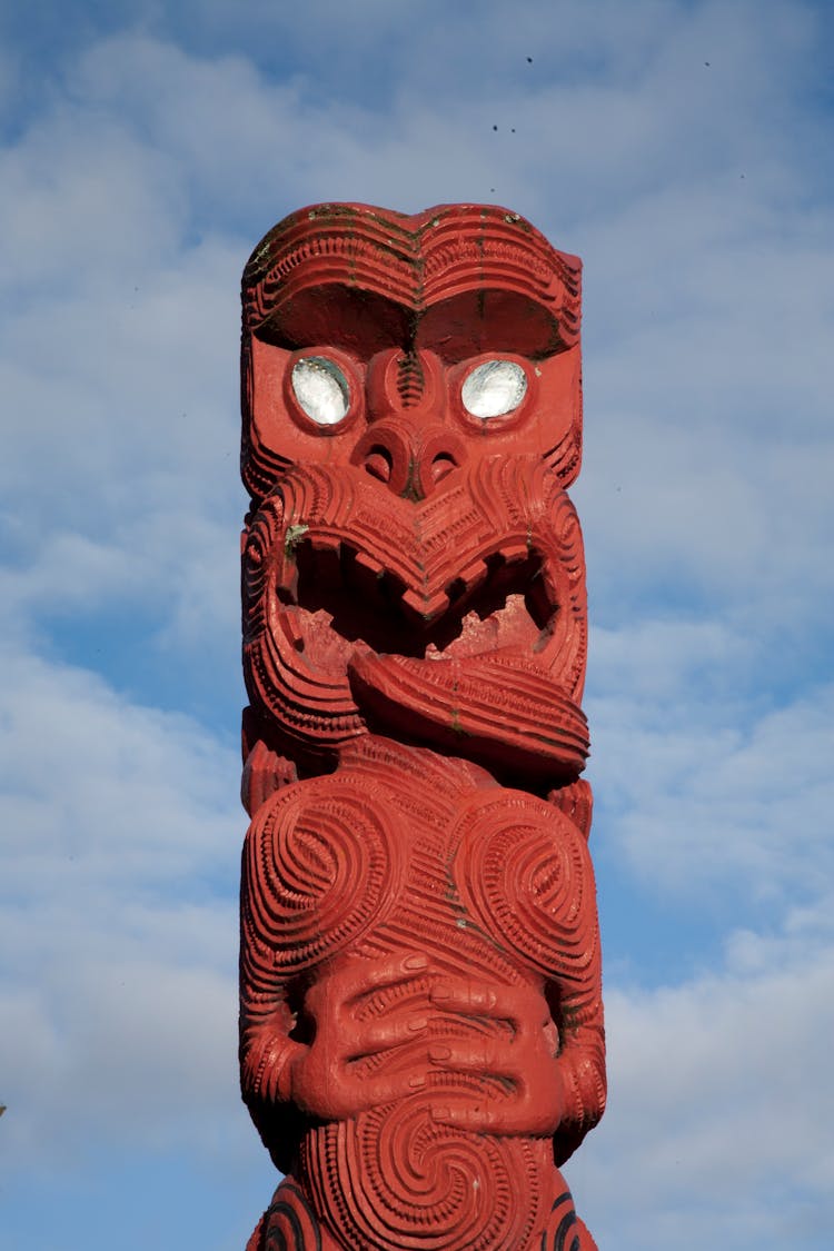 Red Maori Totem Pole Against Blue Sky